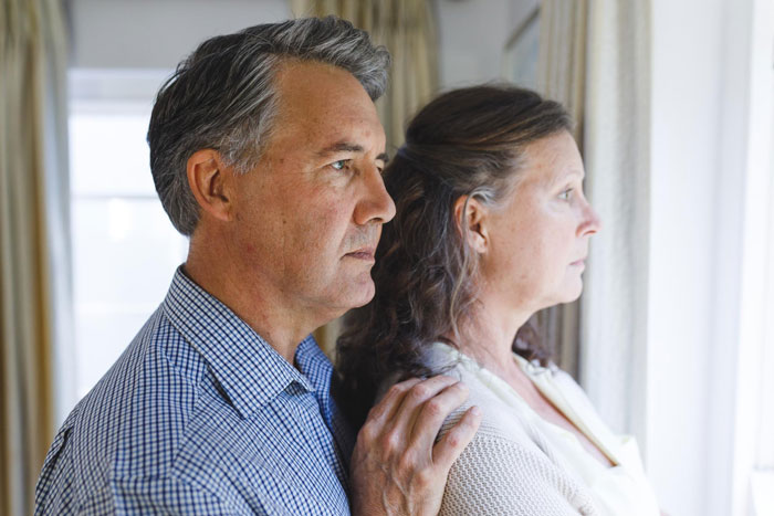 A couple looking out a window, representing the loving parents who turned hostile. A couple looking out a window, representing the loving parents who turned hostile.