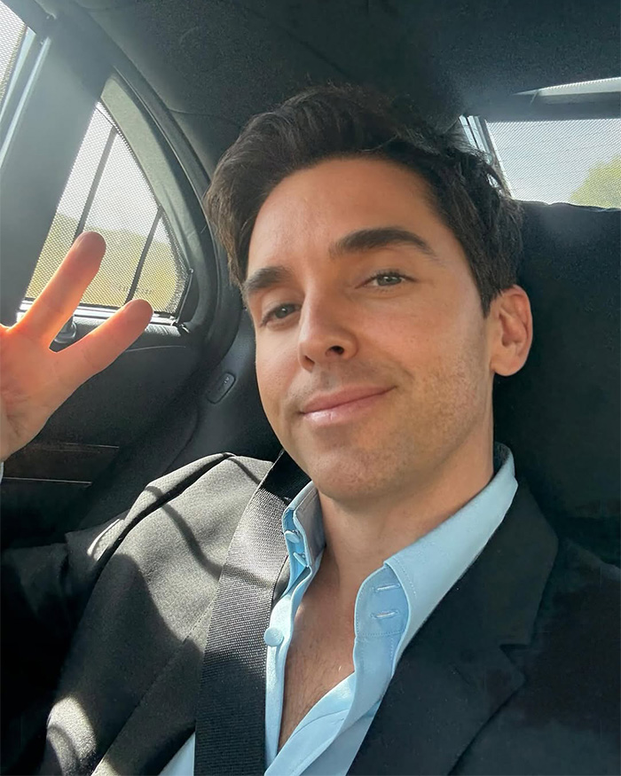Paul W. Downs smiling and making a peace sign in a car selfie Paul W. Downs smiling and making a peace sign in a car selfie