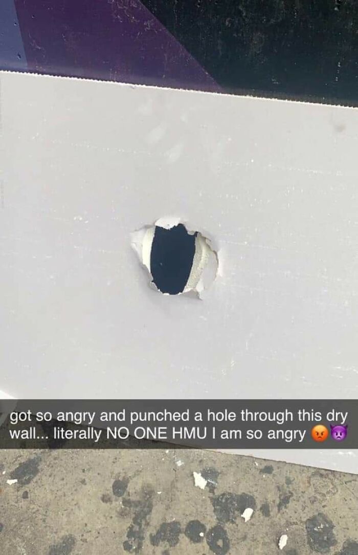 Hole punched in drywall with angry caption showing frustration