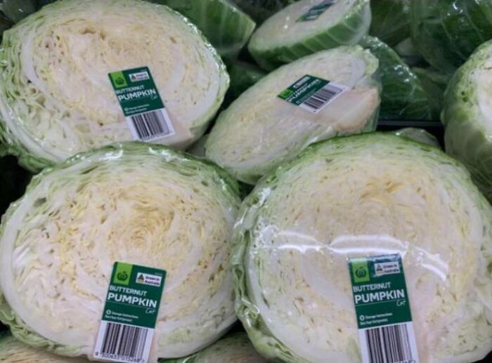 Several heads of cabbage incorrectly labeled as butternut pumpkin in a grocery store, showcasing a one job fail.