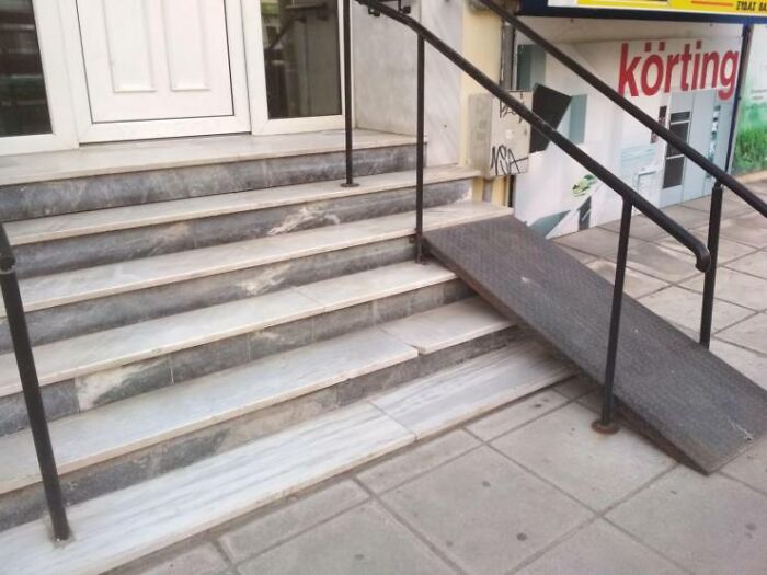 A set of stairs with a short, steep ramp that ends abruptly, showcasing a You Had One Job fail in accessibility.