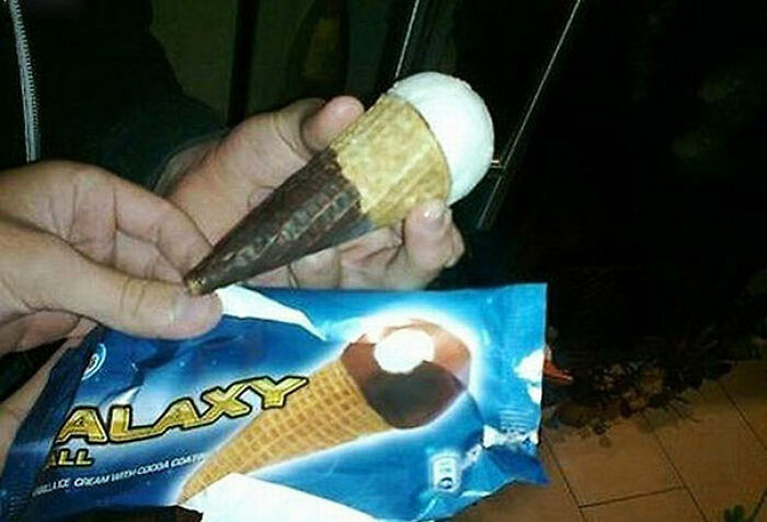 A person holding an ice cream cone that looks nothing like the one on the package, a ridiculous You Had One Job fail.