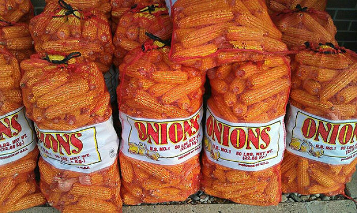 A display of bagged corn mislabeled as onions, highlighting a “You Had One Job” fail.