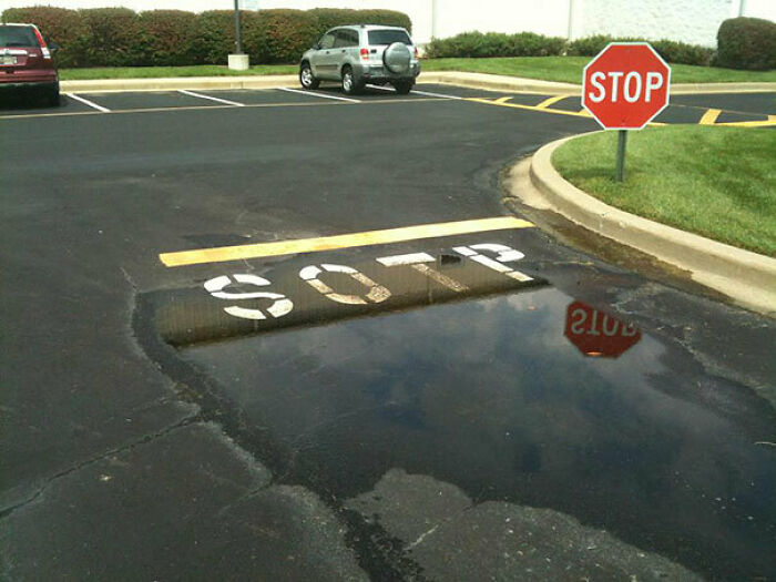 A pavement fail where a stop sign is posted, but the word STOP on the asphalt is misspelled as SOTP, showcasing a common sense fail.