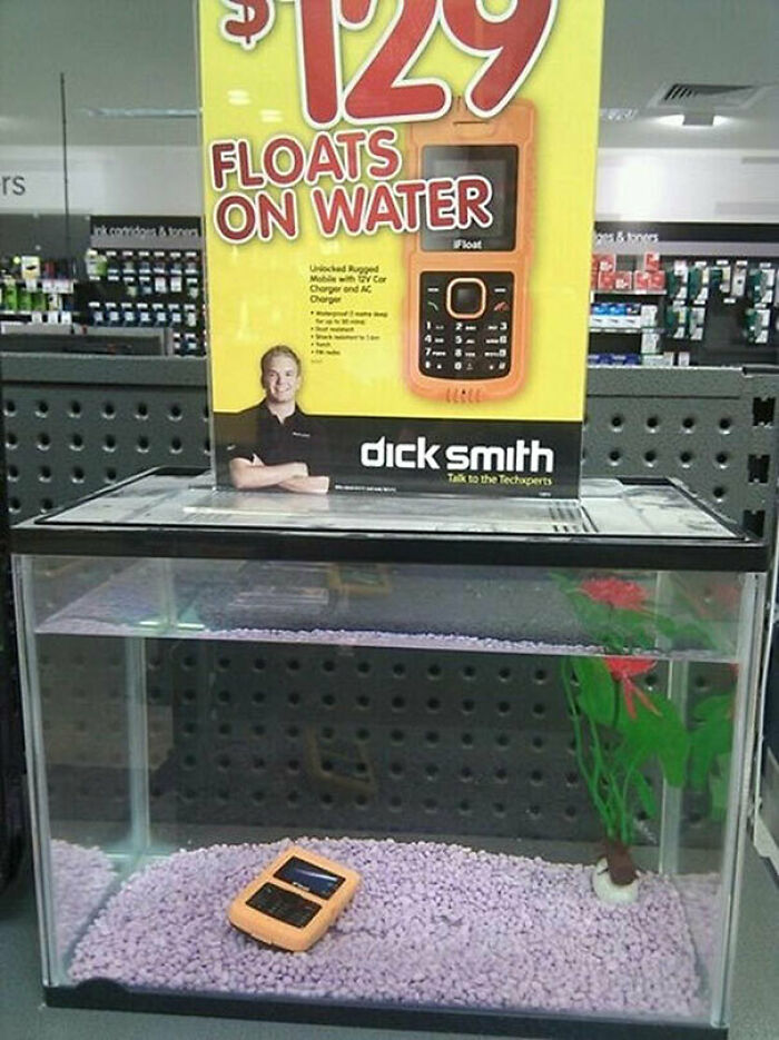 A display for a phone that floats on water, with the phone submerged in an aquarium, a You Had One Job fail.