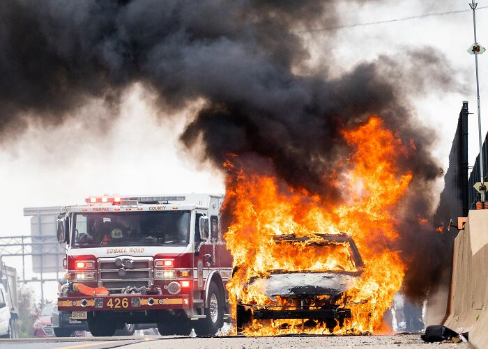 A car on fire with a fire truck nearby, realizing it was not a joke.