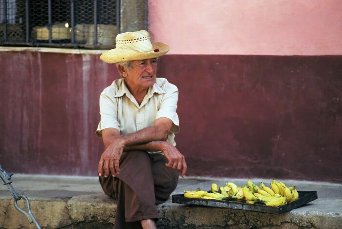 A man with a straw hat and bananas, realizing something was not a joke.