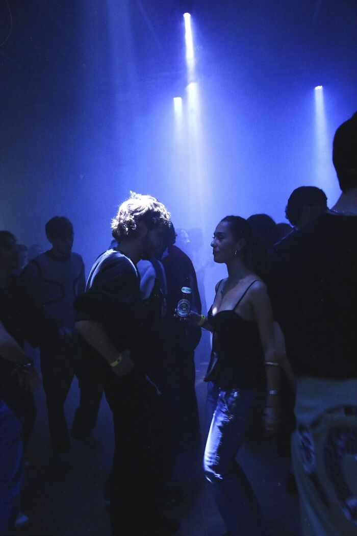Friends dancing under blue lights at a party, capturing the vibrant energy of the photo trend.