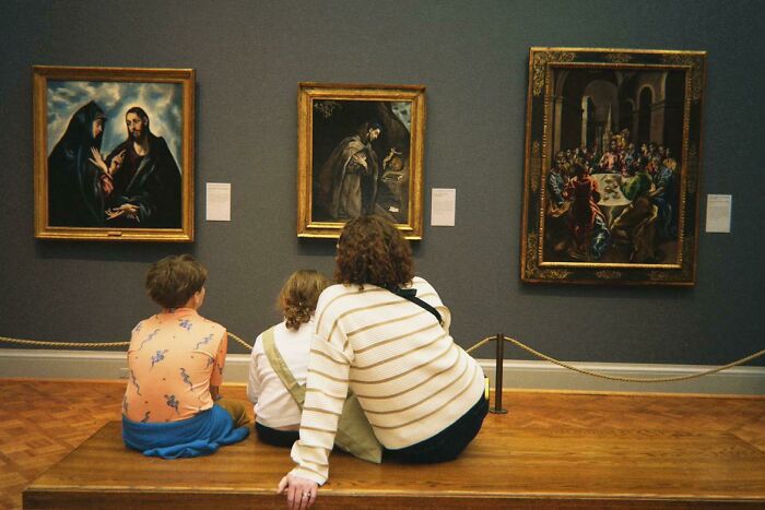 A wholesome photo of people viewing art in a gallery, reflecting the painting-like quality of the trend.