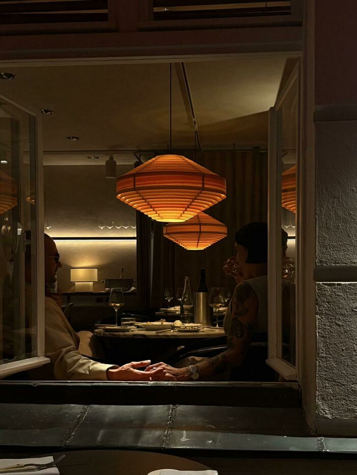 A wholesome photo trend of strangers dining in a restaurant at night, like a painting.