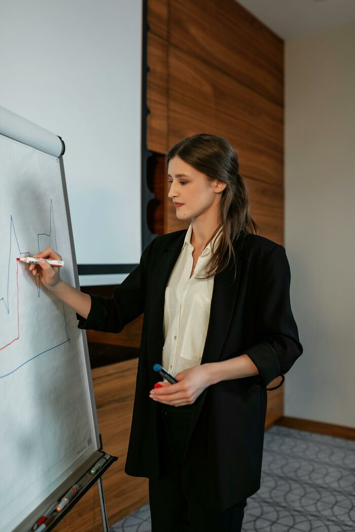 Woman presenting charts during meeting, depicting professional reconnection with old friends