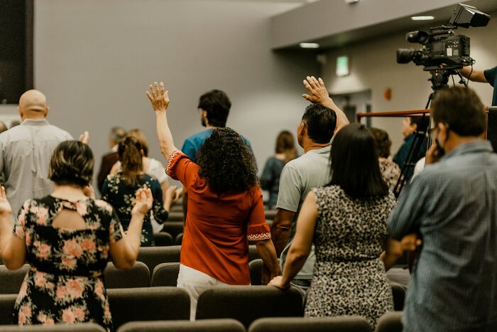 Group of people raising hands during gathering or worship event