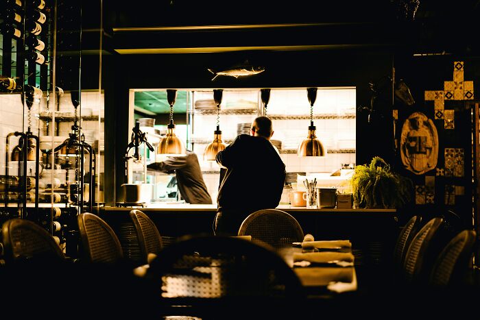 Dimly lit restaurant kitchen showing tension in reconnecting with old friends