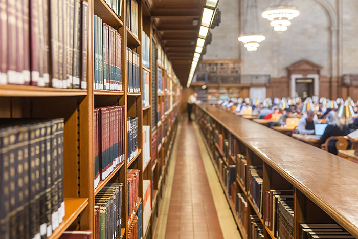 Library with rows of books and people studying in a quiet reading area
