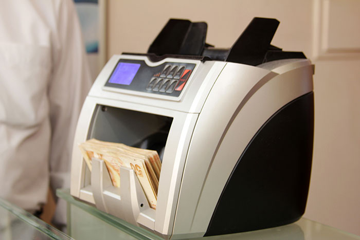 Close-up of counting machine processing currency for rare money counting jobs