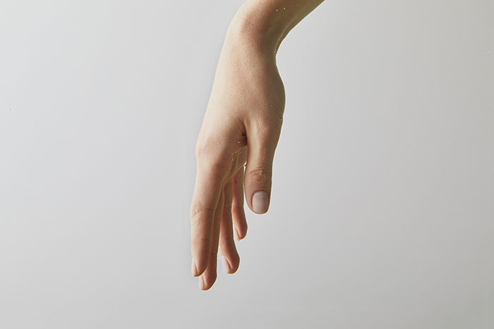 Close-up of a human hand against a plain background