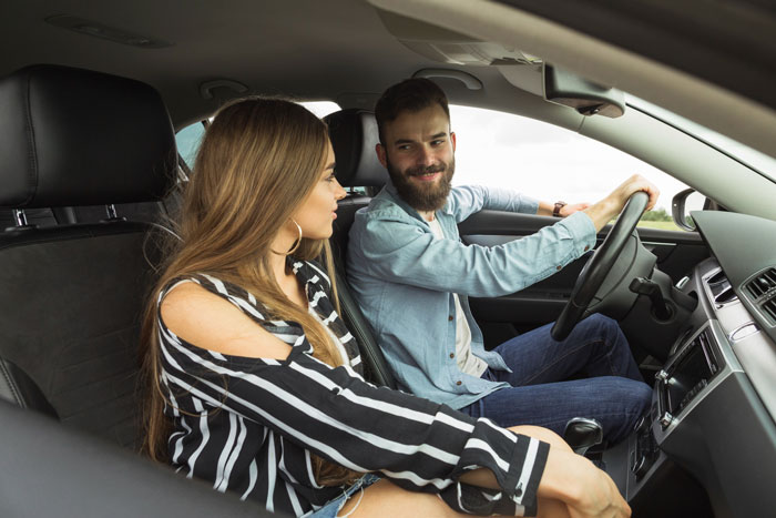 Man driving car while woman sits in passenger seat inside car Man driving car while woman sits in passenger seat inside car