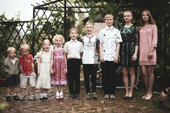 Eight children of varying ages standing in a line, illustrating a large polygamist family.