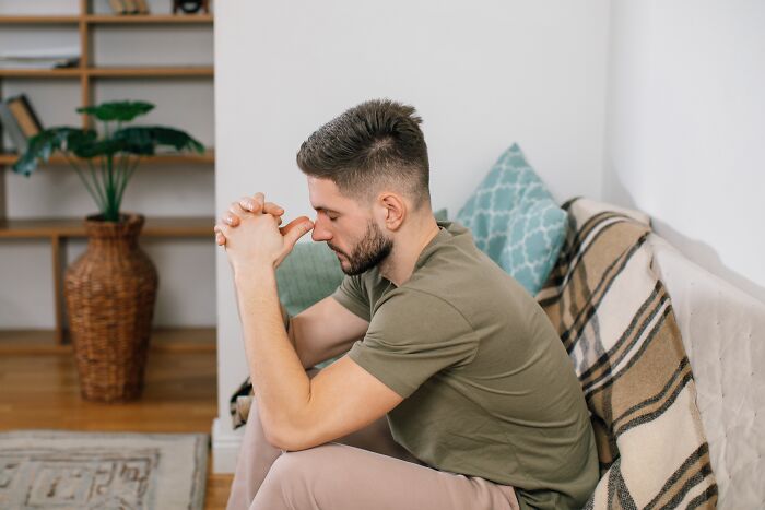 Man sitting on couch in deep thought