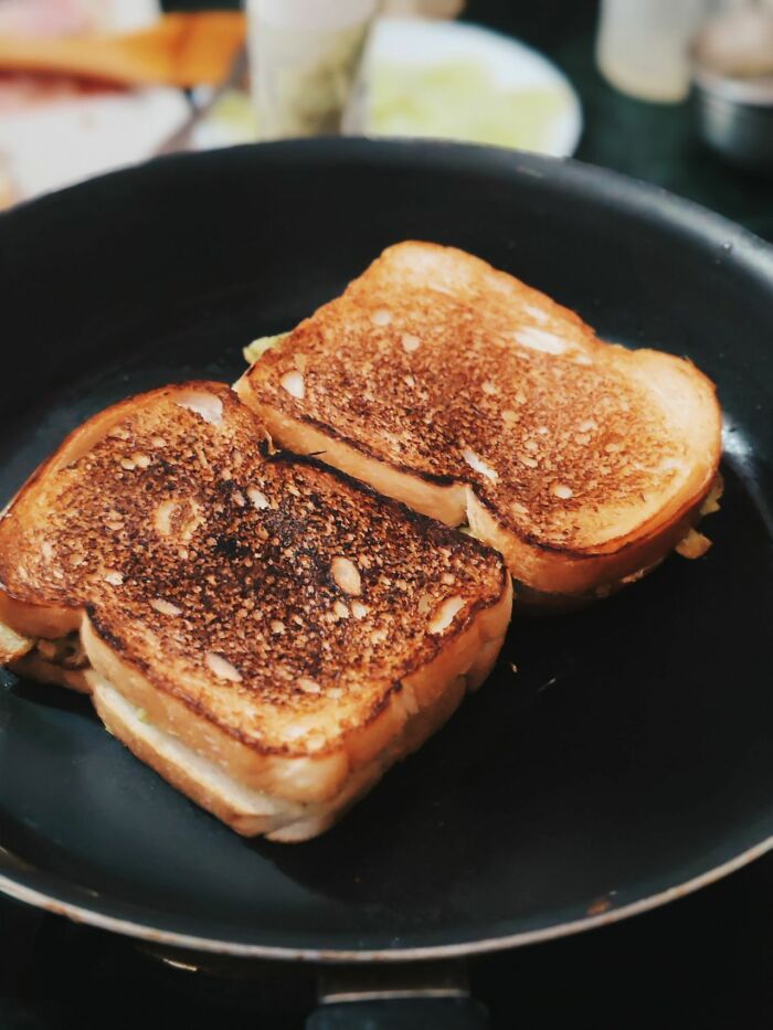 Grilled sandwiches cooking in a pan, unrelated to things found on partners phone.