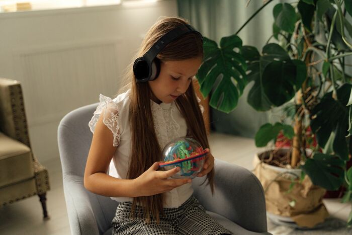 Girl with headphones engaged in activity reflecting Gen Alpha learning challenges
