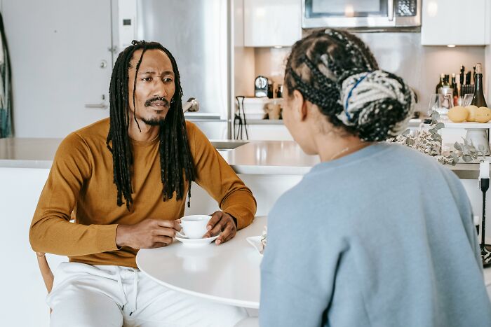 Couple discussing seriously at table during verbal weapon exchange between men and women