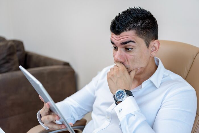 Man shocked looking at tablet screen
