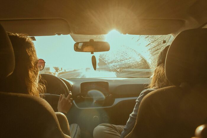 View from backseat of car with bride and groom driving away