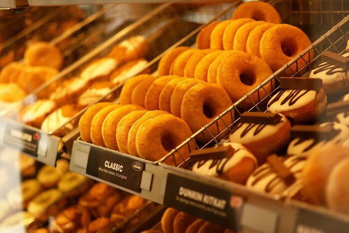 Display of classic and chocolate donuts in bakery showcasing generosity treats