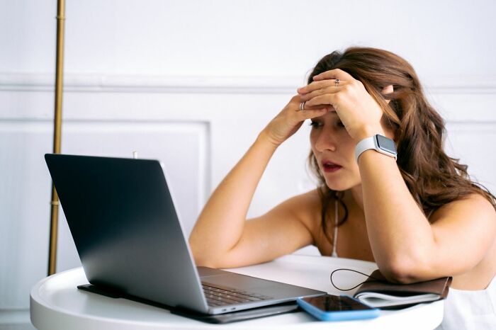 Stressed woman shocked by infidelity stories on laptop screen