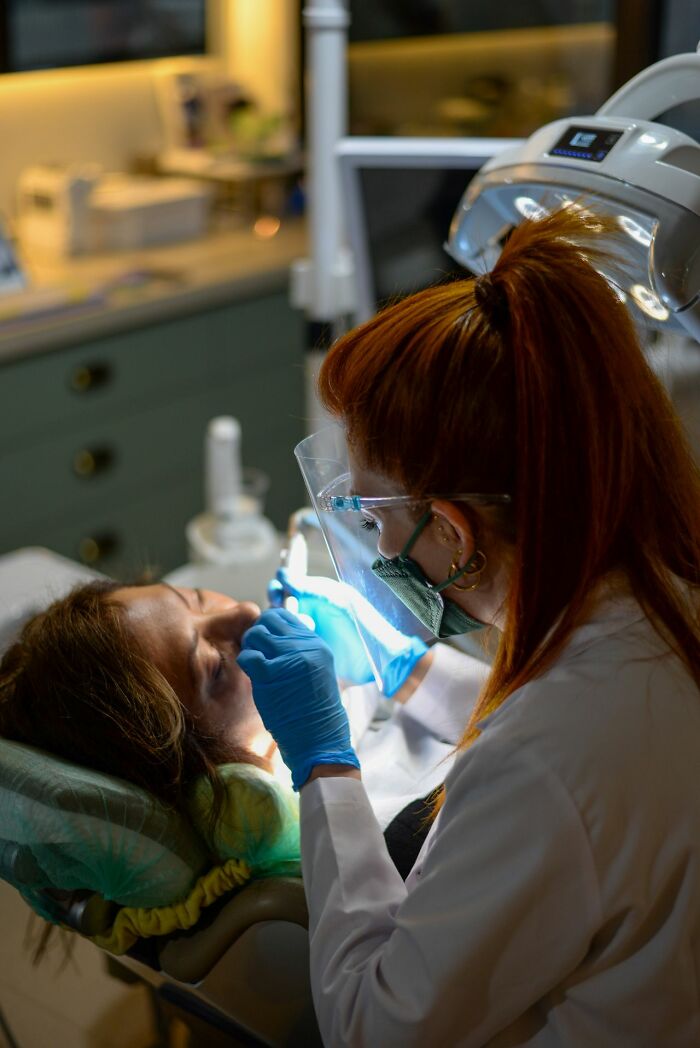 A dentist working on a patient's teeth, which can cause pain.