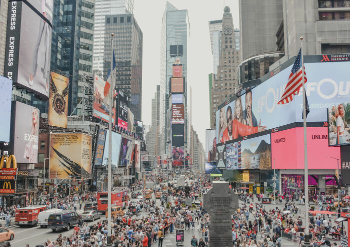 Crowded Times Square in New York City with tall buildings and billboards