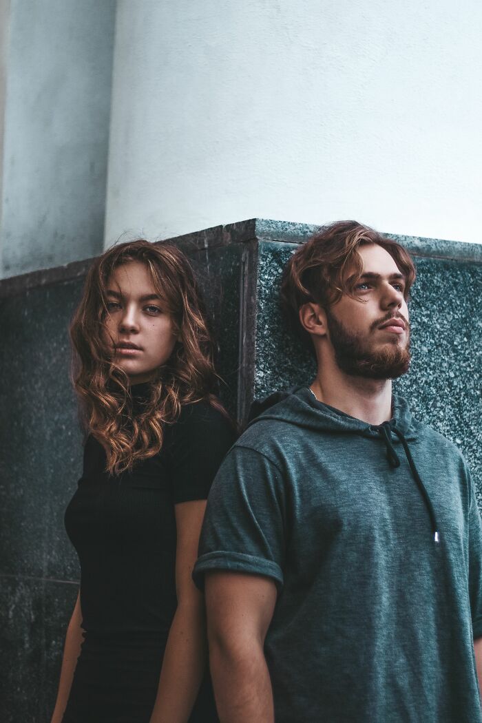 Young man and woman standing against a wall, representing diverse human bodies and unknown facts.