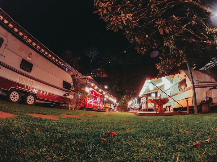 Vintage campers parked under string lights at night, symbolizing diverse stories from polygamist families.