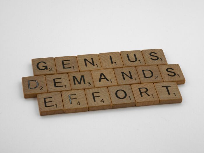 Scrabble tiles spell 'GENIUS DEMANDS EFFORT,' perfect for a word mashups quiz to test general knowledge skills. Scrabble tiles spell 'GENIUS DEMANDS EFFORT,' perfect for a word mashups quiz to test general knowledge skills.
