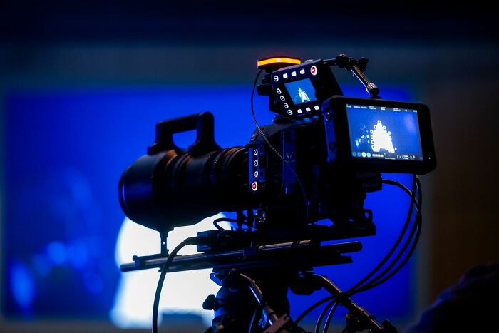 A professional video camera on a tripod, with a blue screen background, demonstrating crazy facts.