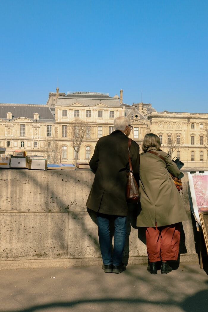 An elderly couple looking at a distant building, experiencing wild coincidences in their journey.