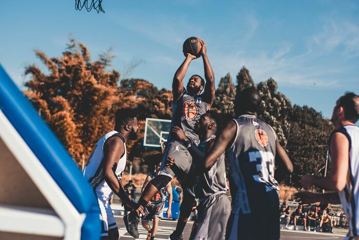Basketball players competing on a court; one player jumps to shoot, showing intense rage mode, couldn't take it anymore.