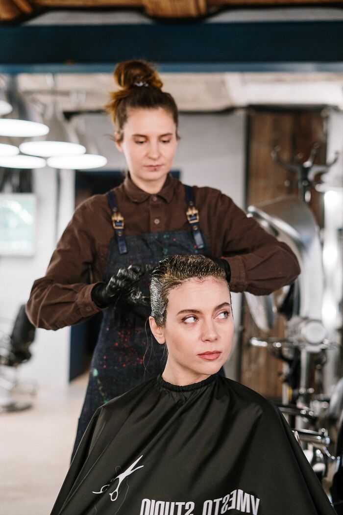 Woman getting her hair dyed in a salon, a situation that could involve hilariously misread social cues.