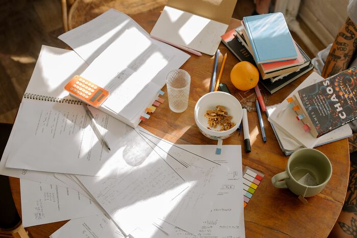 Cluttered desk with papers and books showing anxiety and thought patterns