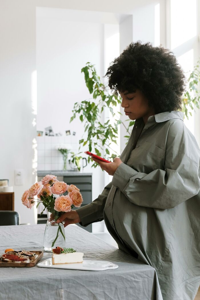 Sad woman checking phone near flowers in cheating and complete idiots story