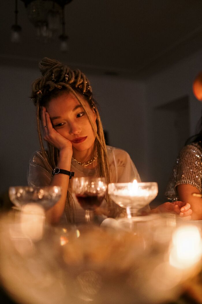 Woman looking thoughtful amid candlelit wedding reception