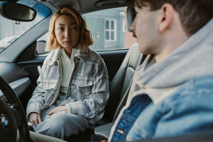 Couple having tense conversation in car about cheating