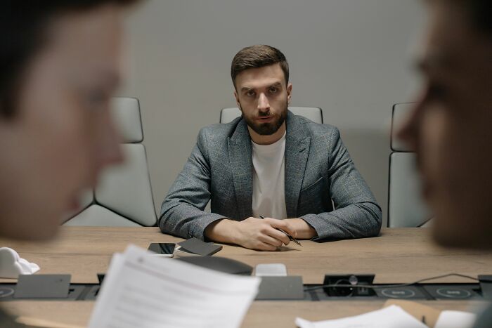 Man serious in meeting illustrating anxiety and psychological stress