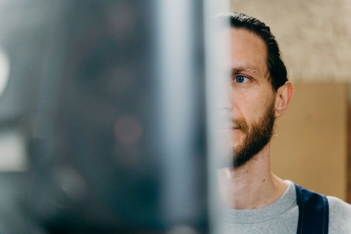 Man partially visible behind a blurred object indoors