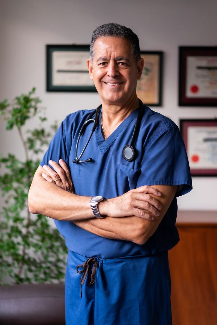 A confident male doctor in blue scrubs and a stethoscope, ready for various ER visits.