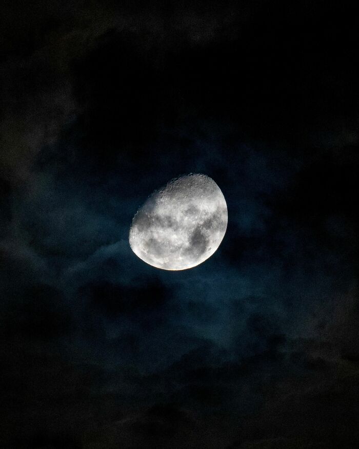 A bright half-moon in a dark, cloudy night sky, an interesting and surprising fact about celestial bodies.