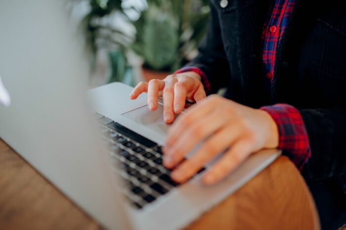 Hands typing on a laptop, a hint that a person is secretly very smart through focused work.