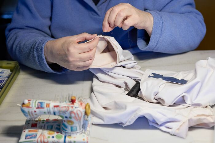 Hands sewing fabric, symbolizing people reaching full rage mode and snapping.