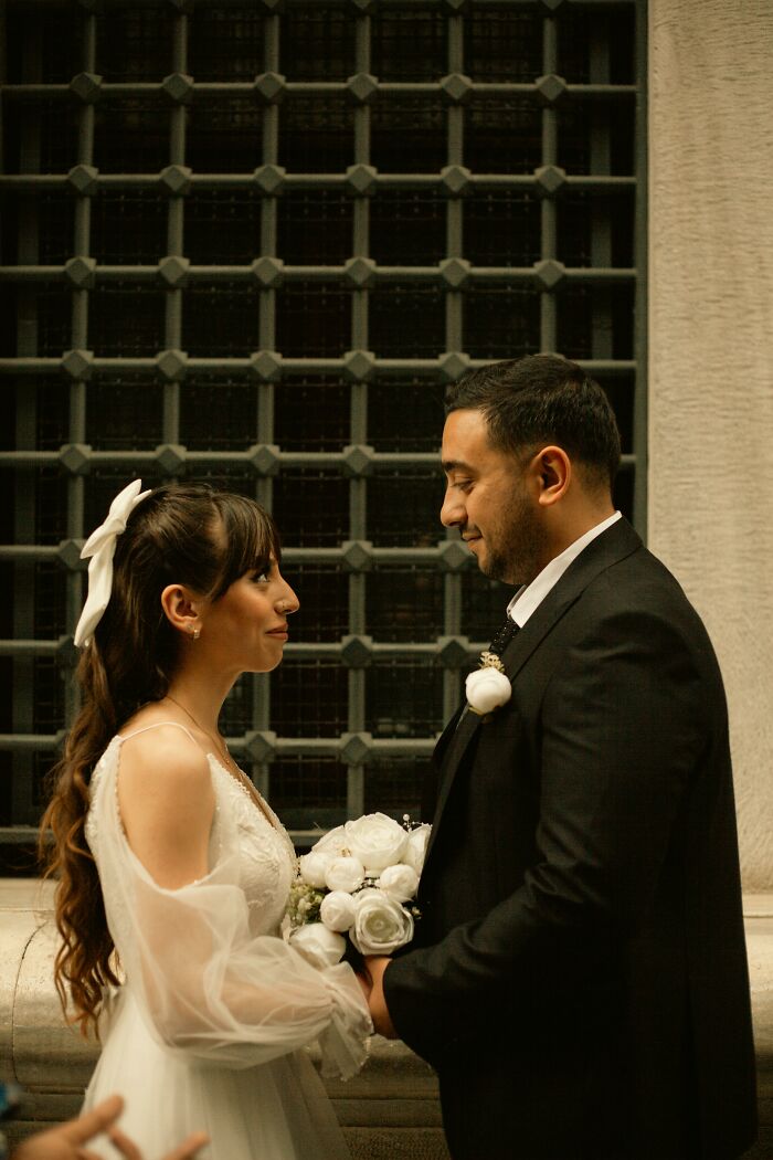 Couple facing each other during wedding ceremony with bouquet